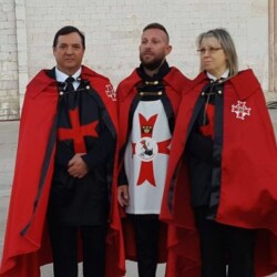 ASSISI 4 OTTOBRE 2018 - BASILICA DI: "S. FRANCESCO"
(NOMINA DI:"GRAN PRIORE D'ITALIA" DEI TEMPLARI FEDERICIANI). FRONTALMENTE A DX LA DUCHESSA DONNA "MARIA ASSUNTA dé FRASSINE" E "DAMA" DEI:"TEMPLARI FEDERICIANI" DALLE PROPRIE MANI DEL G.M. "CORRADO MARIA ARMERI" DEI "TEMPLARI FEDERICIANI" CON ONORE E COMMOZIONE ACCOGLIE NELLE SUE PROPRIE MANI LE "MOSTRINE" VERE E PROPRIE CON IL COLORE DISTINTIVO DEL ROSSO E LA "CROCE" ROSSA AD INDICARE L'APPARTENENZA DEI "TEMPLAI" AL "CRISTIANESIMO" E PER RICORDARE IL SANGUE VERSATO DI "CRISTO" CON IL DIRITTO DI APPLICARLA SULLA SPALLA SX VERSO IL CUORE DELLA PROPRIA MANTELLA TEMPLARE PER LA NOMINA AVVENUTA DI:" "GRAN PRIORE D'ITALIA" DEI "TEMPLARI FEDERICIANI".